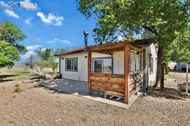 rear view of house with a pergola and a patio