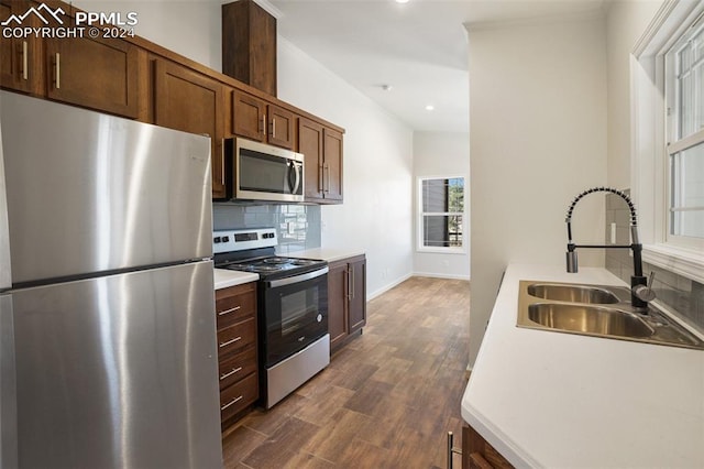 kitchen featuring tasteful backsplash, dark hardwood / wood-style flooring, stainless steel appliances, and sink