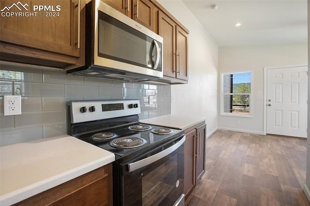 kitchen featuring backsplash, hardwood / wood-style flooring, and stainless steel appliances