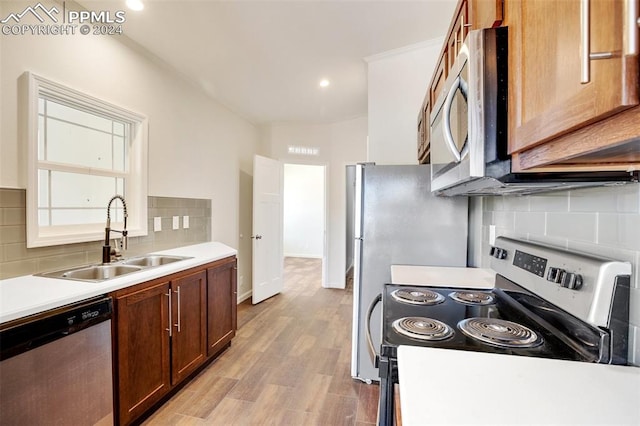 kitchen with sink, light hardwood / wood-style flooring, tasteful backsplash, and stainless steel appliances