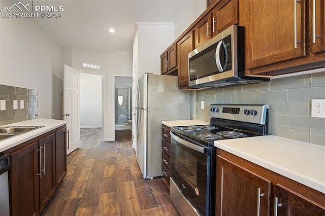 kitchen with stainless steel appliances, crown molding, dark hardwood / wood-style floors, tasteful backsplash, and sink