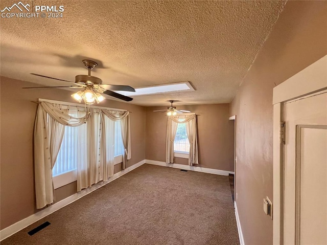 carpeted spare room featuring ceiling fan and a textured ceiling