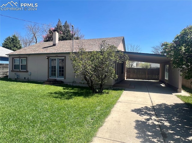 view of front of house with a carport and a front lawn