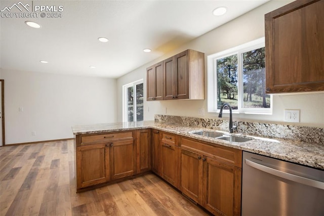 kitchen featuring light hardwood / wood-style floors, sink, stainless steel dishwasher, and kitchen peninsula