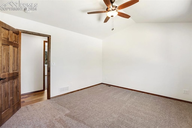 unfurnished room with ceiling fan, light carpet, and vaulted ceiling