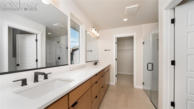 bathroom with tile patterned floors, vanity, and a shower with door