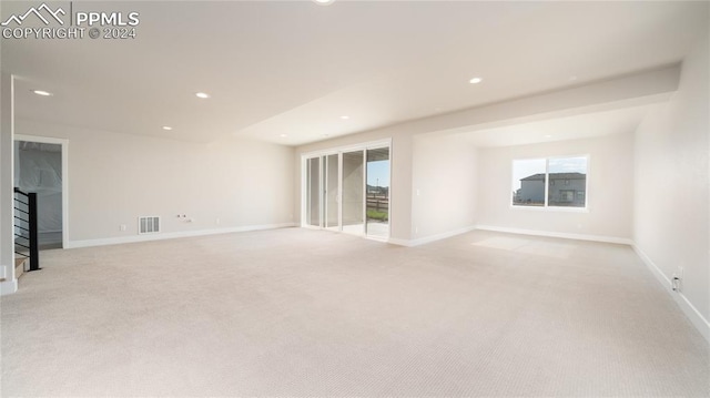 unfurnished room featuring plenty of natural light and light colored carpet