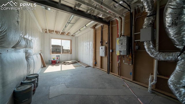 misc room with concrete flooring, electric panel, and water heater