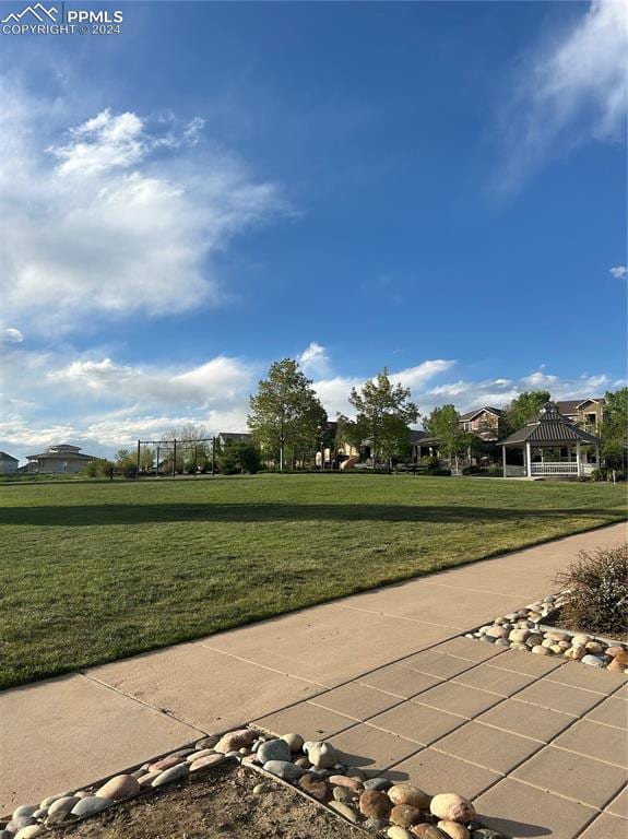 surrounding community featuring a yard, a trampoline, and a gazebo