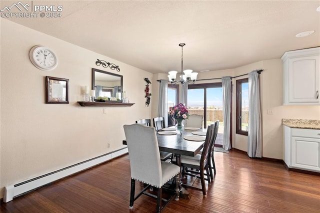 dining room featuring dark hardwood / wood-style flooring, a baseboard heating unit, and a notable chandelier