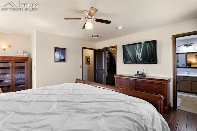 tiled bedroom with a closet, connected bathroom, a spacious closet, and ceiling fan