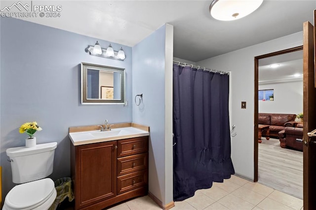 bathroom with toilet, tile floors, and vanity