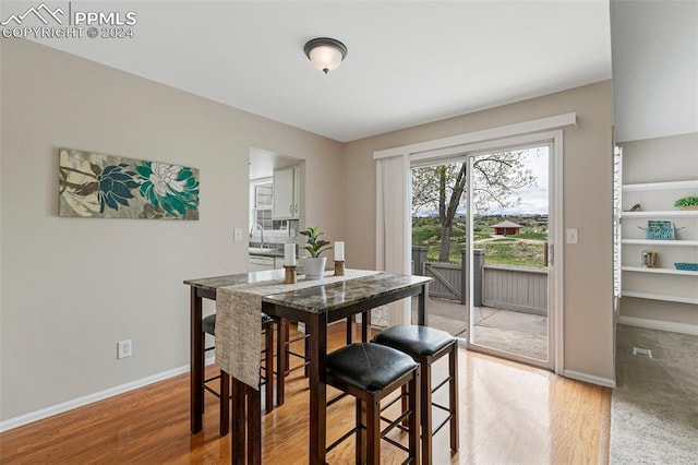 dining room featuring sink and light hardwood / wood-style flooring