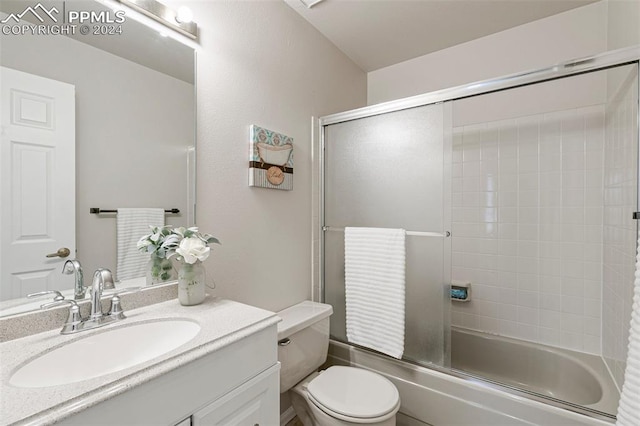 full bathroom featuring enclosed tub / shower combo, vanity, and toilet