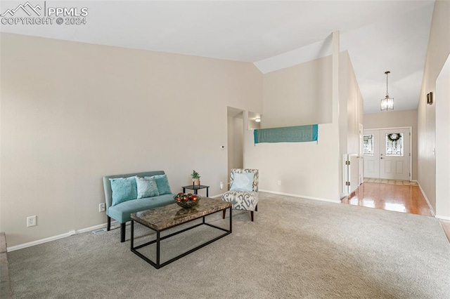 living area featuring carpet and high vaulted ceiling