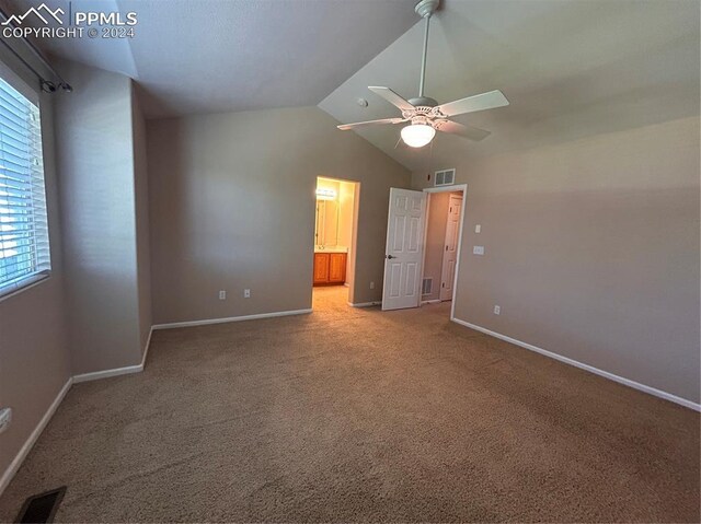 unfurnished bedroom featuring carpet flooring, ensuite bath, vaulted ceiling, and ceiling fan