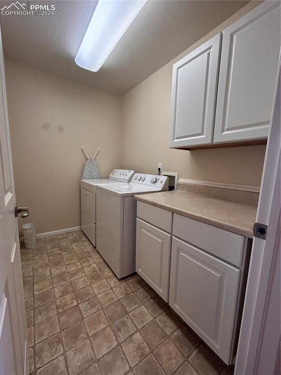 clothes washing area with cabinets and washer and dryer