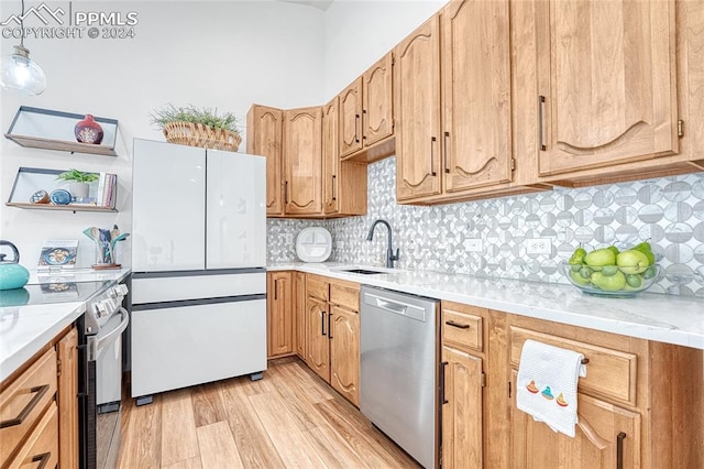 kitchen with sink, electric range, white refrigerator, stainless steel dishwasher, and light hardwood / wood-style floors