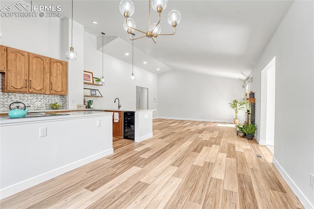 kitchen featuring pendant lighting, light hardwood / wood-style flooring, backsplash, wine cooler, and an inviting chandelier