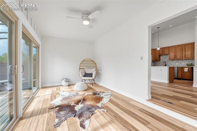 living area with sink, ceiling fan, and light hardwood / wood-style floors