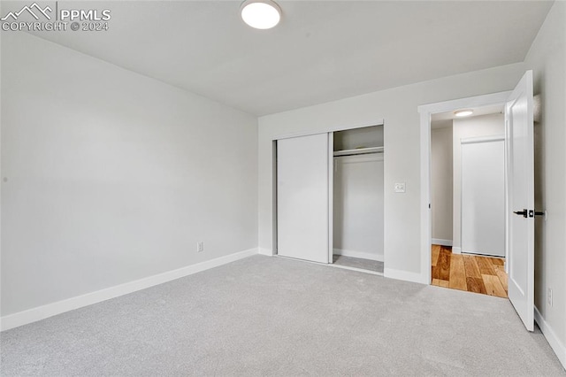 unfurnished bedroom featuring carpet and a closet