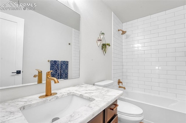 full bathroom with tiled shower / bath, toilet, and vanity