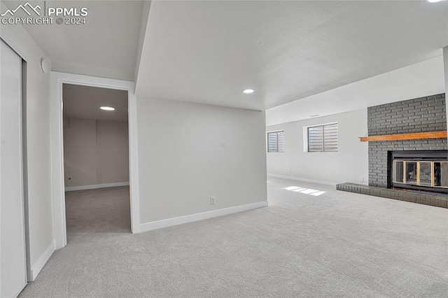 unfurnished living room featuring carpet and a fireplace