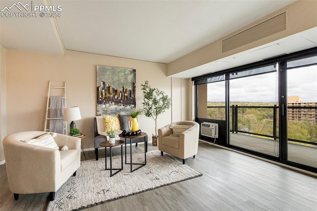 living room featuring hardwood / wood-style flooring and a wall unit AC