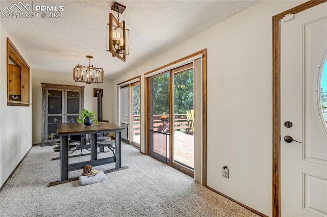 carpeted dining room featuring a textured ceiling and a chandelier