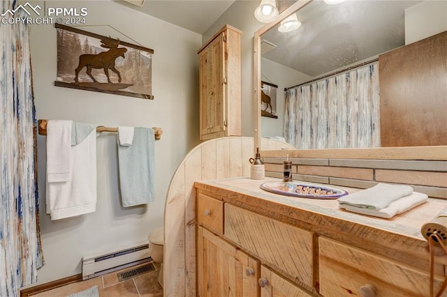 bathroom featuring tile floors, vanity with extensive cabinet space, a baseboard radiator, and toilet