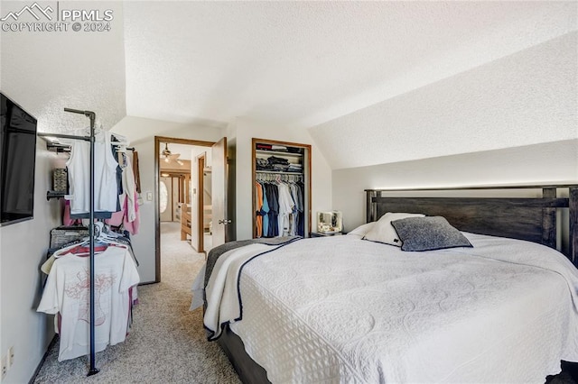 carpeted bedroom featuring vaulted ceiling, a closet, and a textured ceiling