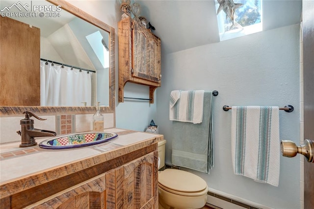 bathroom featuring a baseboard heating unit, oversized vanity, and toilet