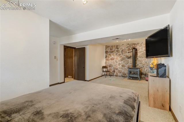 bedroom with carpet and a wood stove