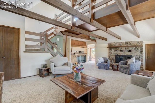 carpeted living room featuring a stone fireplace and beam ceiling