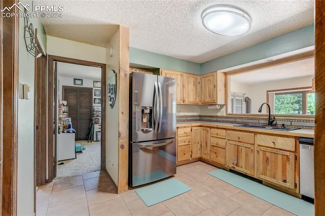 kitchen featuring appliances with stainless steel finishes, sink, and light tile floors