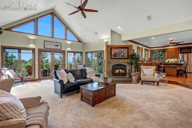 living room featuring light carpet, a fireplace, ceiling fan, and high vaulted ceiling