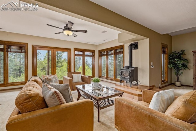 living room with ceiling fan and a wood stove