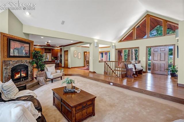 living room with ceiling fan, light hardwood / wood-style floors, lofted ceiling, and a fireplace