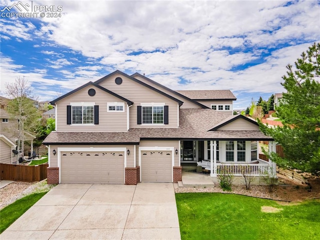 view of front of home with covered porch, a garage, and a front lawn