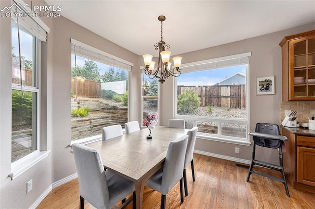 dining area featuring light hardwood / wood-style floors, a wealth of natural light, and a notable chandelier