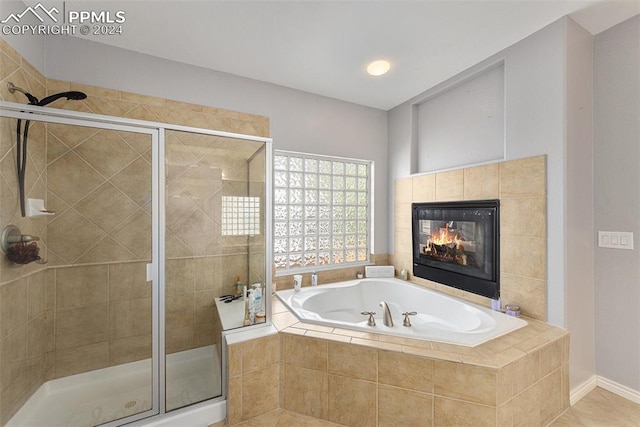 bathroom with a tiled fireplace, tile patterned floors, and separate shower and tub