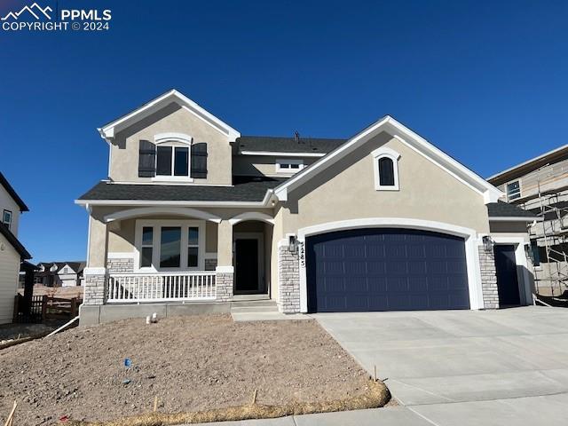 view of front of home featuring covered porch, a front yard, a mountain view, and a garage