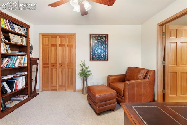 sitting room with ceiling fan and light colored carpet