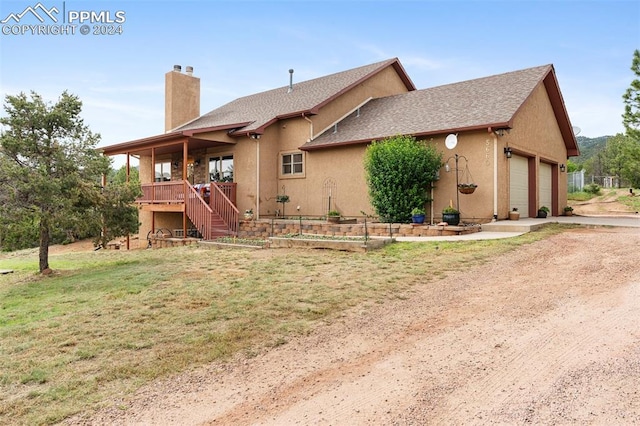 rear view of house with a yard and a garage