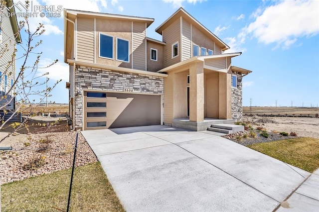 contemporary home with a garage, stone siding, and concrete driveway