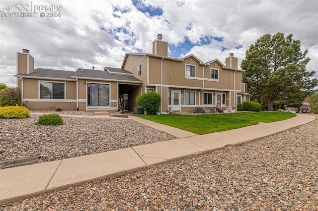 view of front of property featuring central AC unit and a front yard