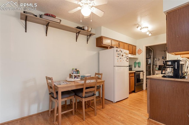 kitchen featuring a textured ceiling, ceiling fan, electric range, white refrigerator, and light hardwood / wood-style floors