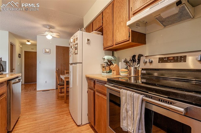 kitchen with a textured ceiling, stainless steel appliances, ceiling fan, and light hardwood / wood-style floors