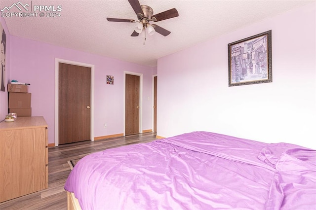 bedroom with a textured ceiling, ceiling fan, and light hardwood / wood-style floors