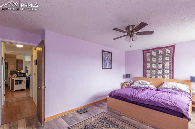 bedroom featuring ceiling fan, hardwood / wood-style flooring, and a textured ceiling